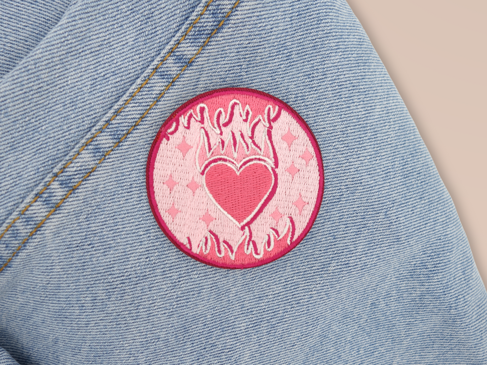 Flammendes Herz Patch auf hellblauer Jeans aufgebügelt