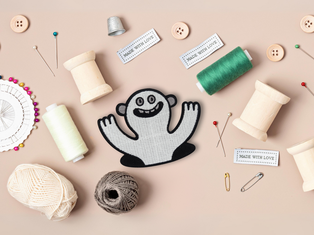Lustiges Monster Patch mit Nähzeug im Hintergund
