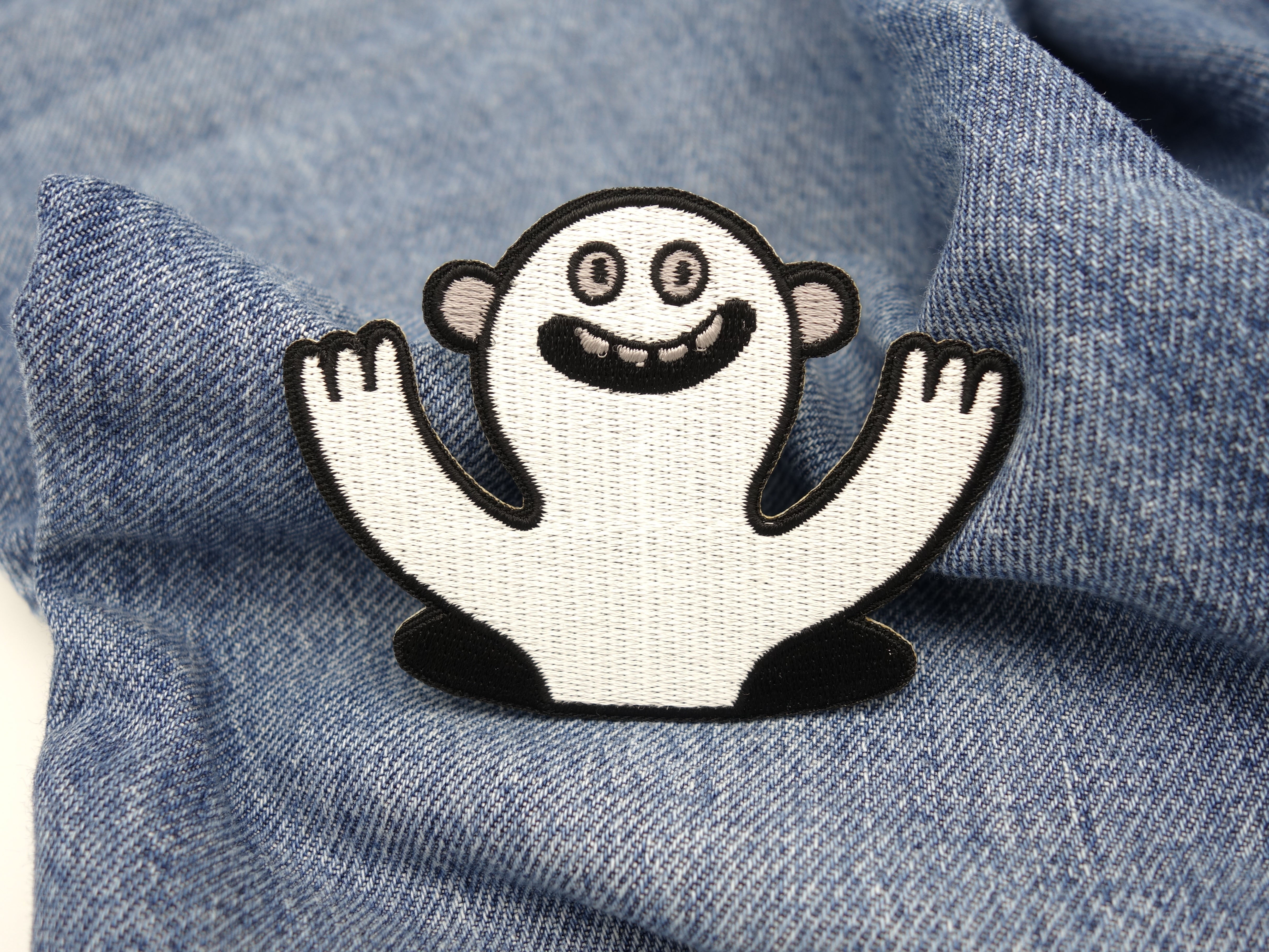 Lustiges Monster Patch auf blauer Jeans