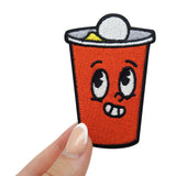 Bier Pong Becher Patch gehalten von einer Frauenhand 