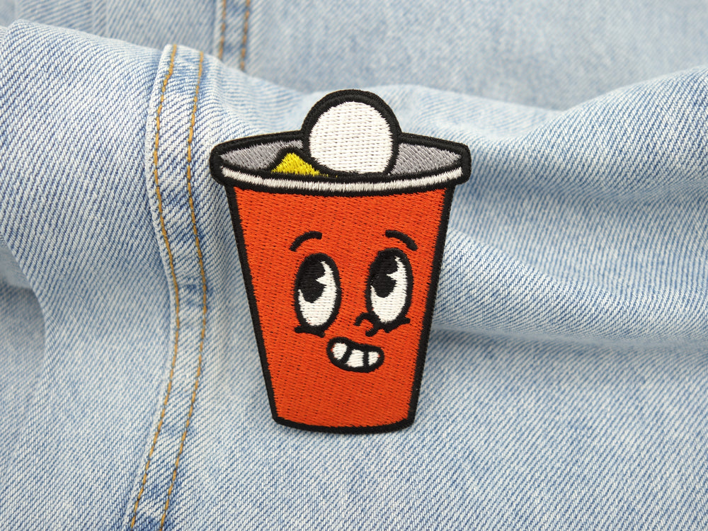 Bier Pong Becher Patch auf hellblauer Jeans