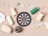 Dartscheibe Patch mit Nähzeug im Hintergrund