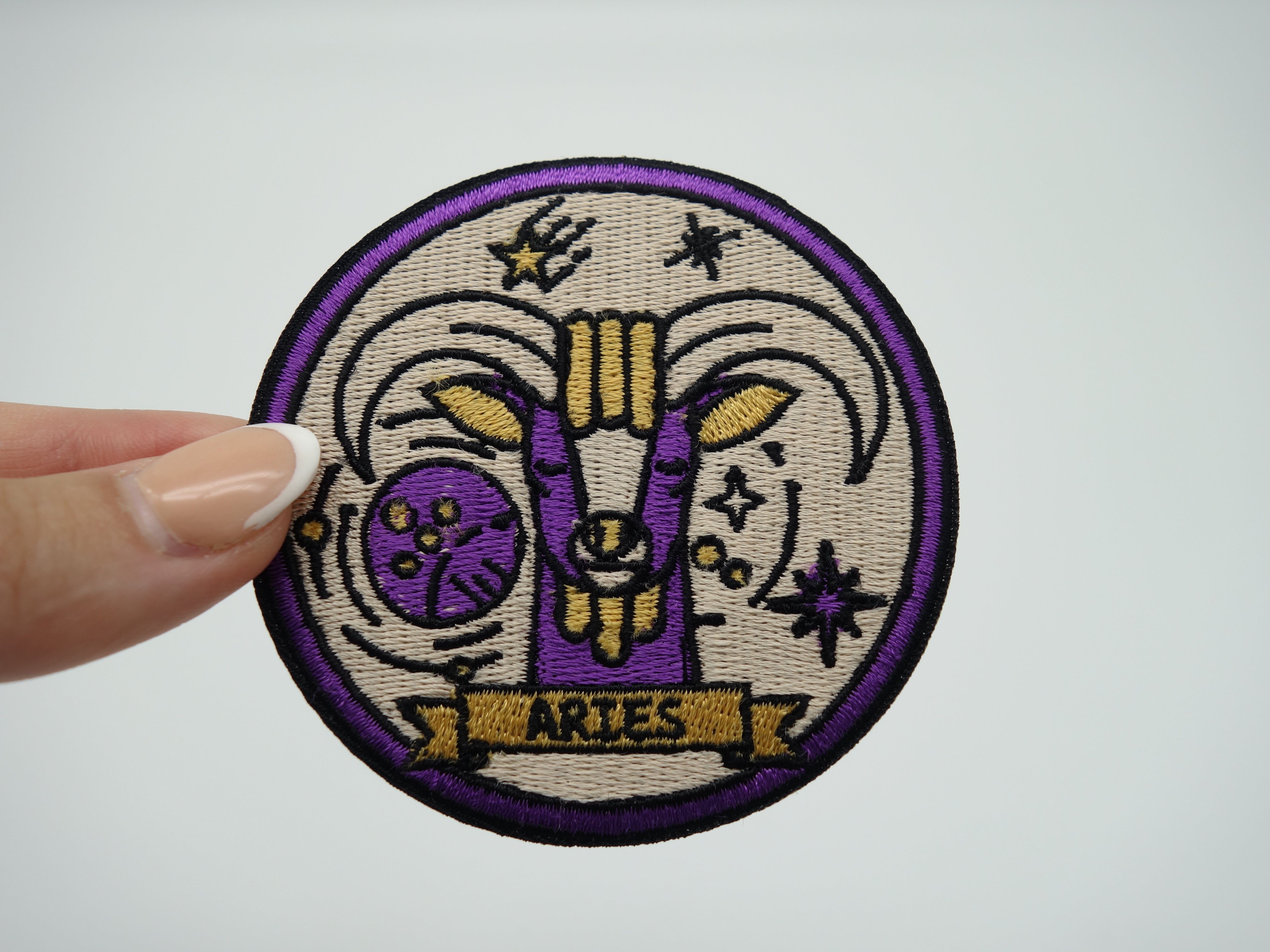 Frauenhand hält den Widder Sternzeichen Patch