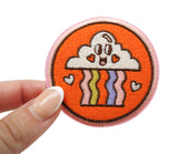 Frauenhand hält den Regenbogen Patch