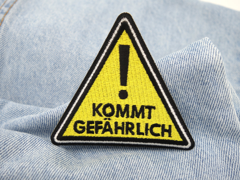 Kommt Gefährlich Patch auf hellblauer Jeans
