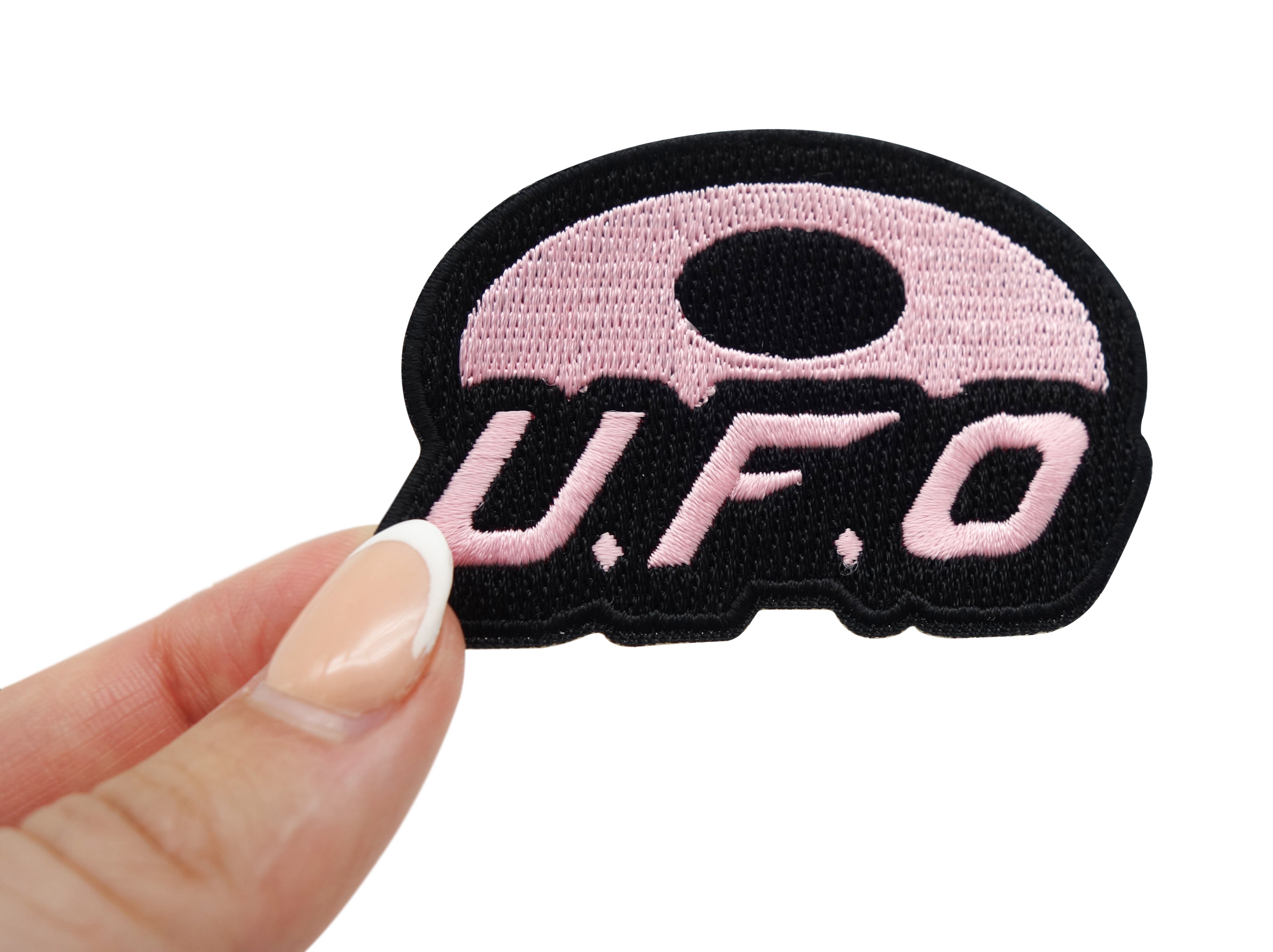 Frauenhand hält den UFO Patch