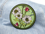 Grüner Blumen Patch auf hellblauer Jeans