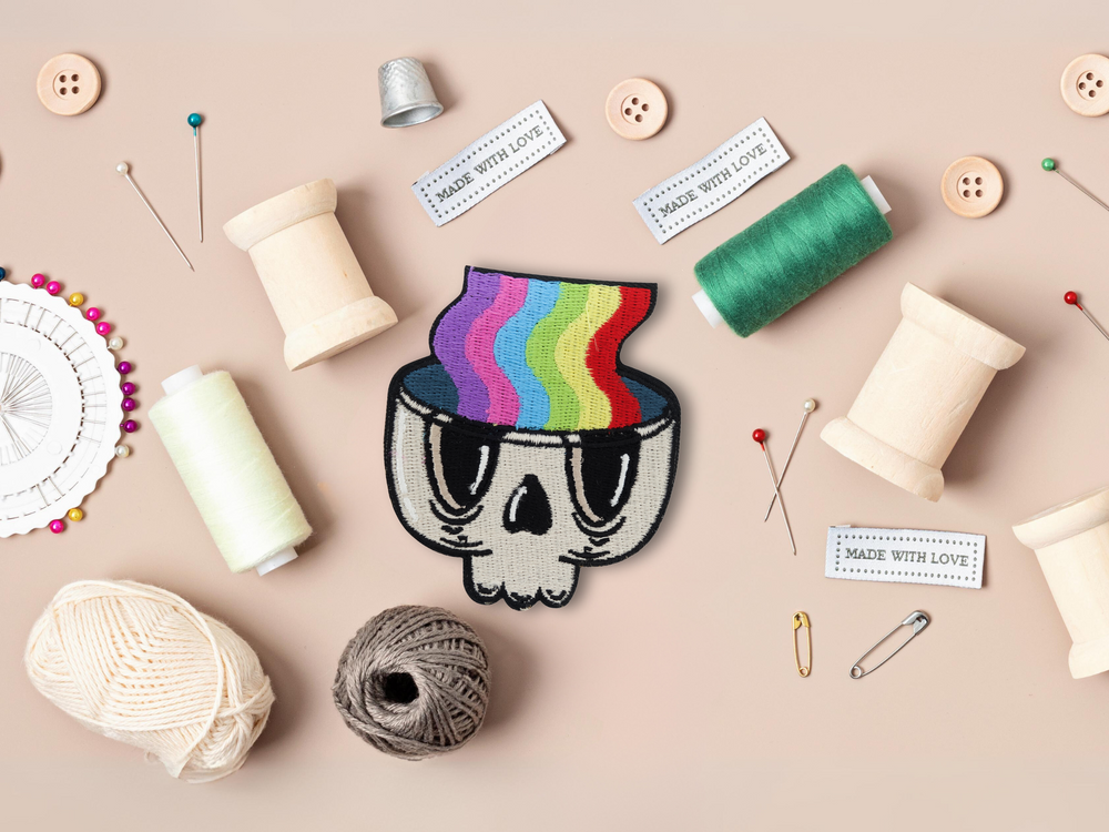 Regenbogen im Totenkopf Patch mit Nähzeug im Hintergrund