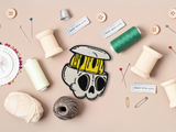 Totenschädel Patch mit Nähzeug im Hintergrund