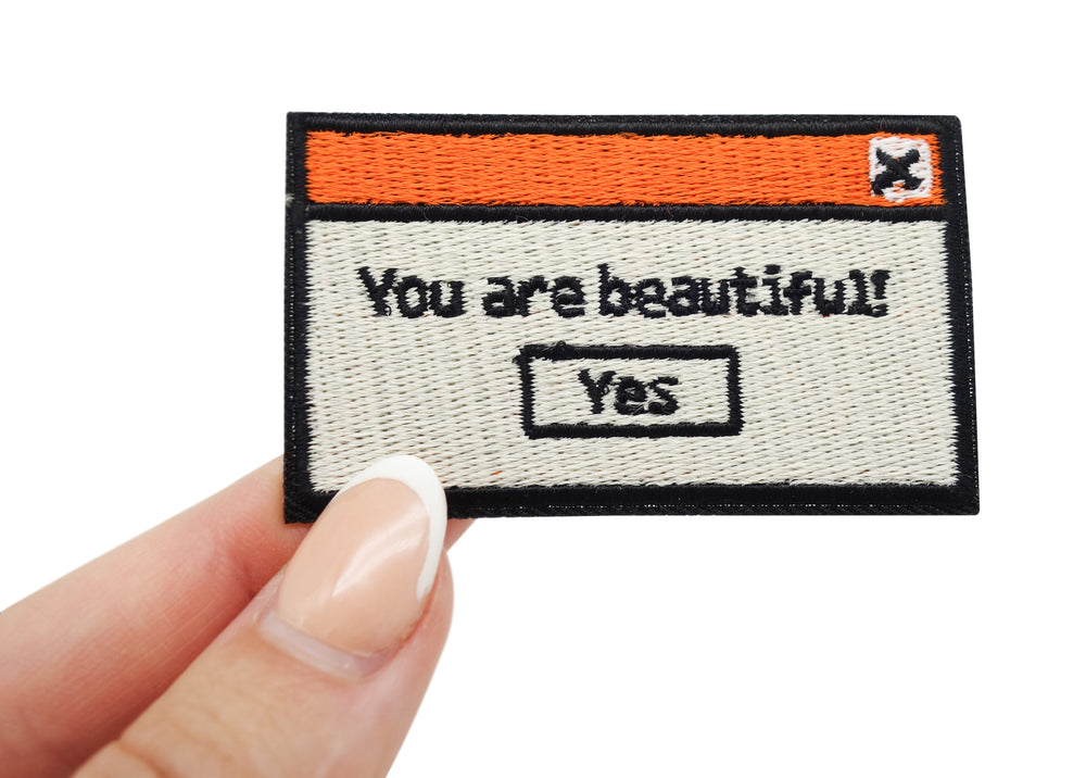 Frauenhand hält den You are beautiful Patch