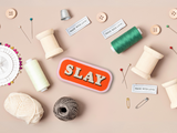 Slay Patch mit Nähzeug im Hintergrund