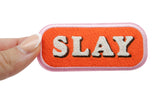 Frauenhand hält den Slay Patch
