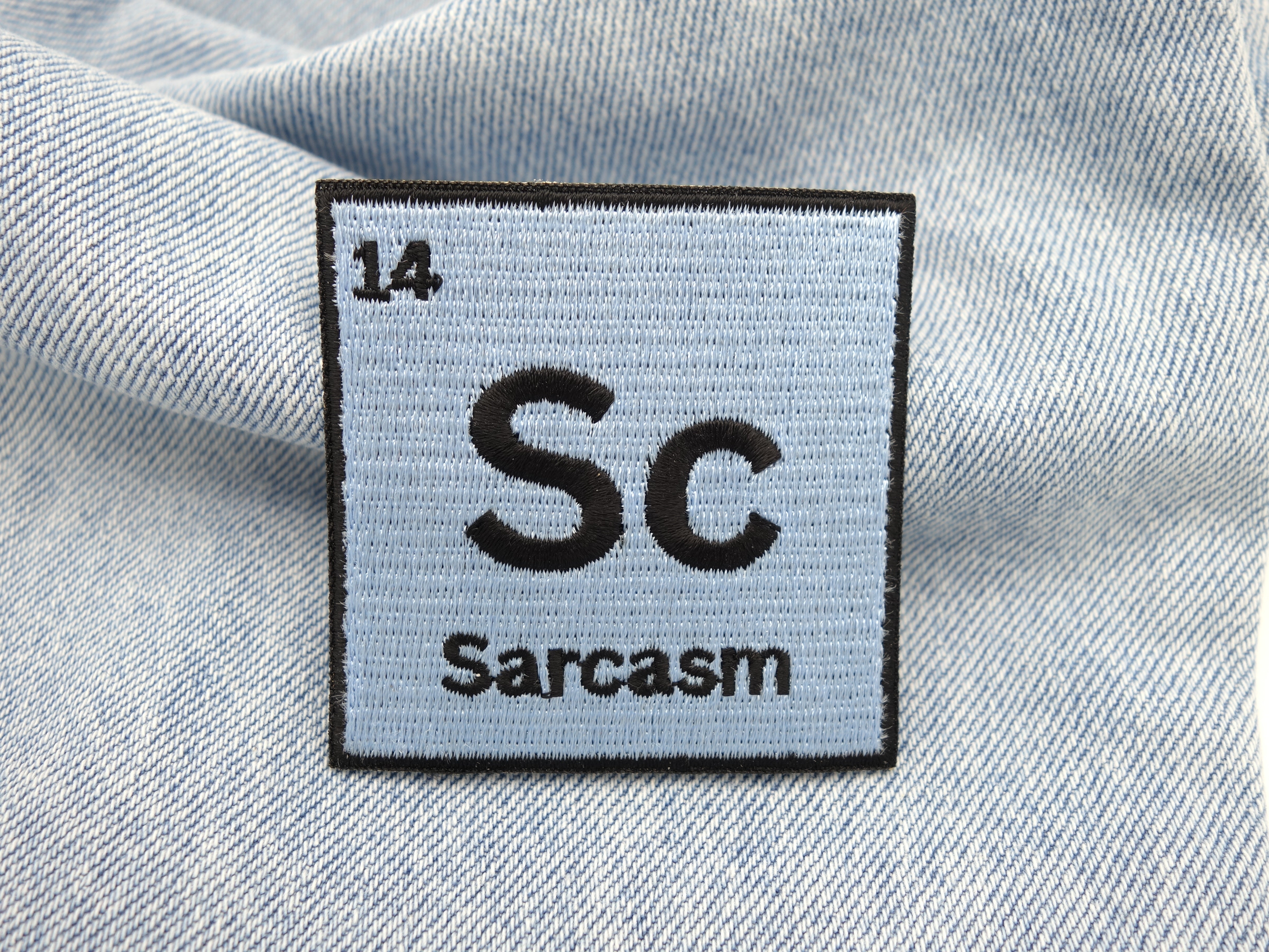 Sarcasm Patch auf hellbaluer Jeans