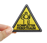 Frauenhand hält den Warndreieck Patch