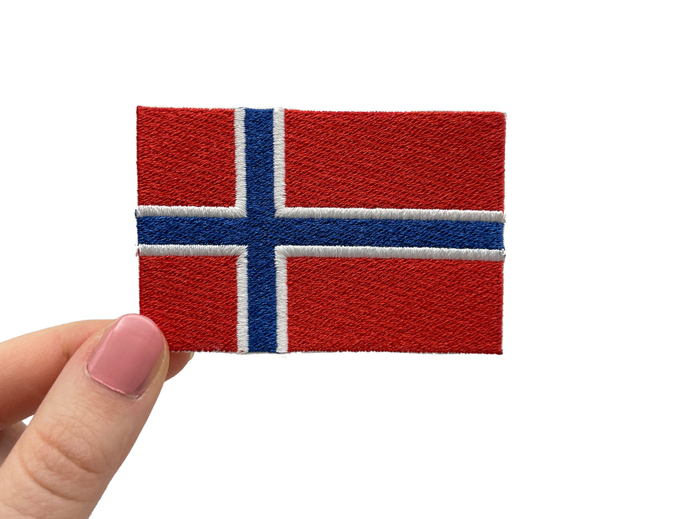 Frauenhand hält den Norwegen Flagge Patch
