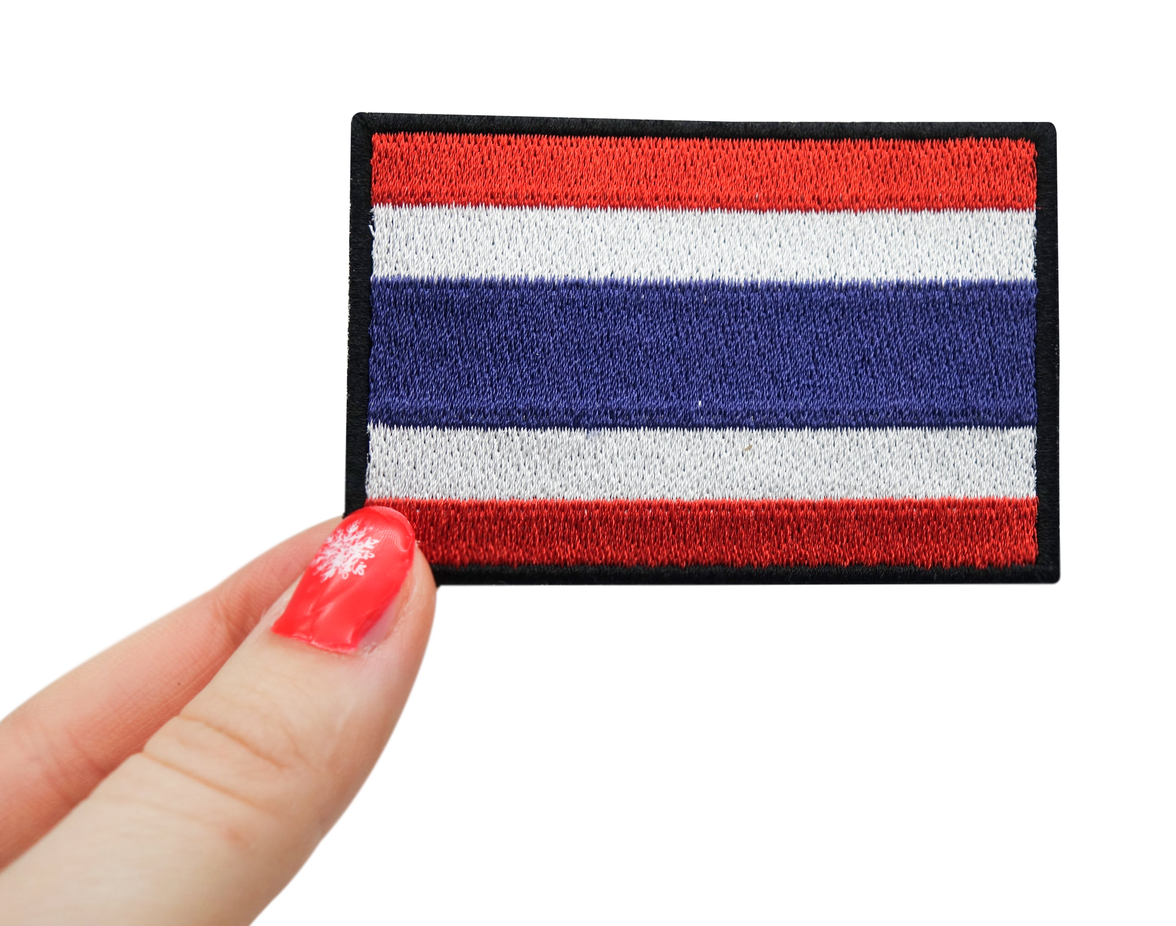 Frauenhand hält den Thailand Klettpatch
