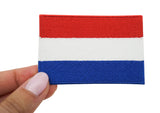 Frauenhand hält den Niederlande Flagge Patch