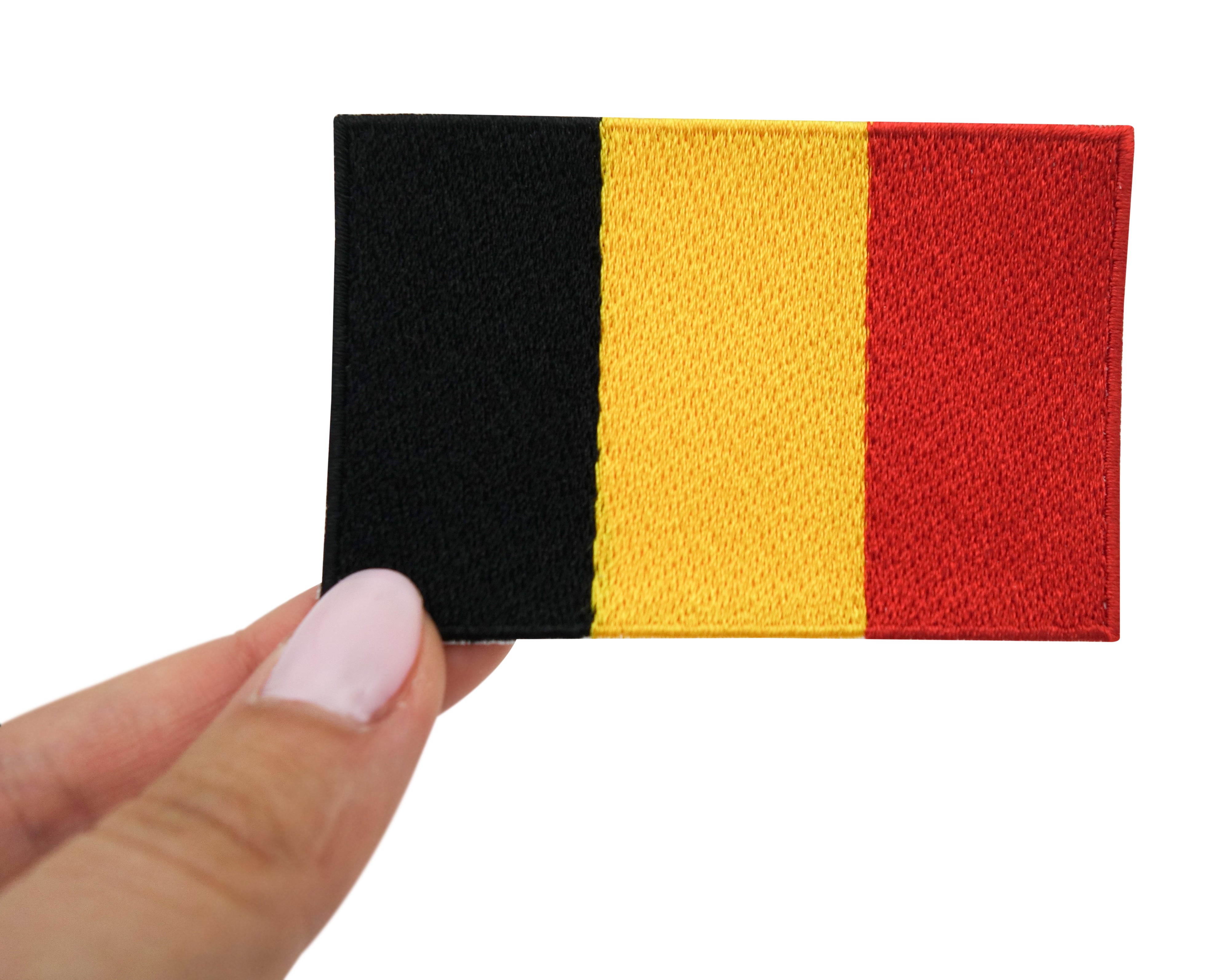 Frauenhand hält den Belgische Flagge Patch