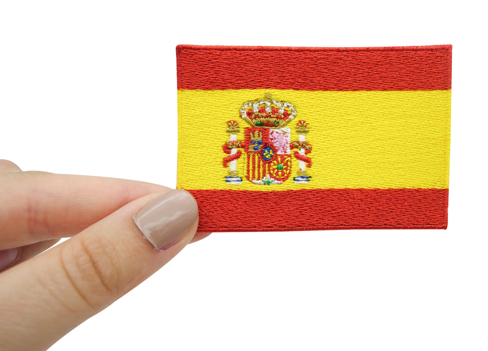 Frauenhand hält den Spanien Flaggen Patch