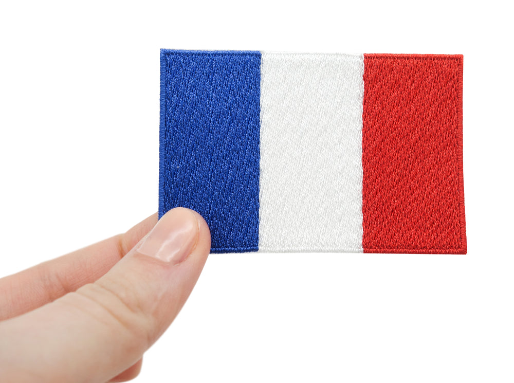 Frauenhand hält den Frankreich Flagge Patch