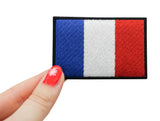 Frauenhand hält den Frankreich Flagge Klettpatch