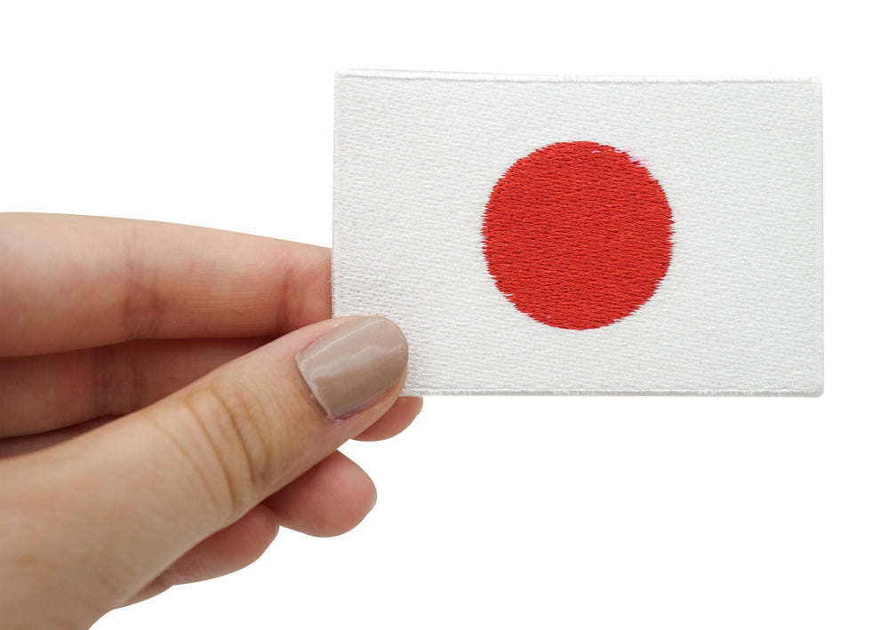Japanischer Flaggen Patch in Frauenhand gehalten